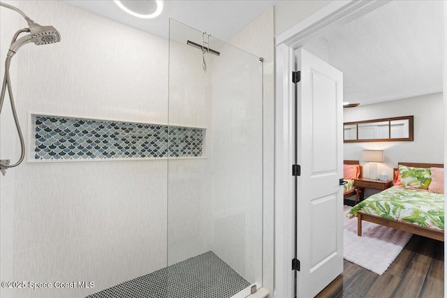 ensuite bathroom with ensuite bath, tiled shower, and wood finished floors