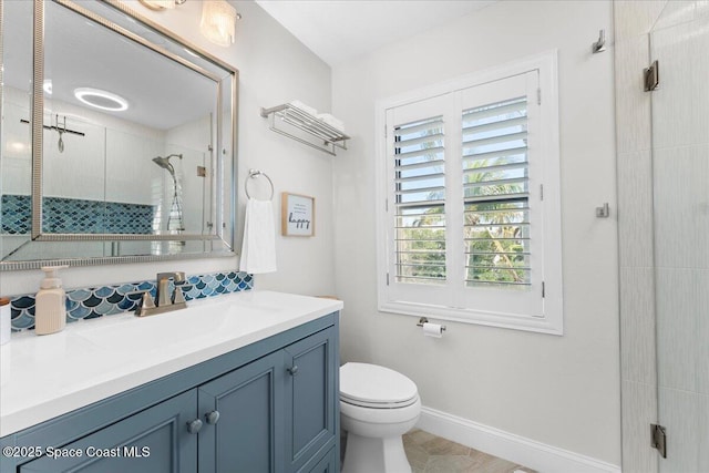 full bath with vanity, a shower stall, toilet, and baseboards