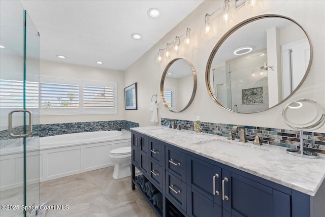 bathroom featuring a sink, backsplash, a bath, a shower stall, and double vanity