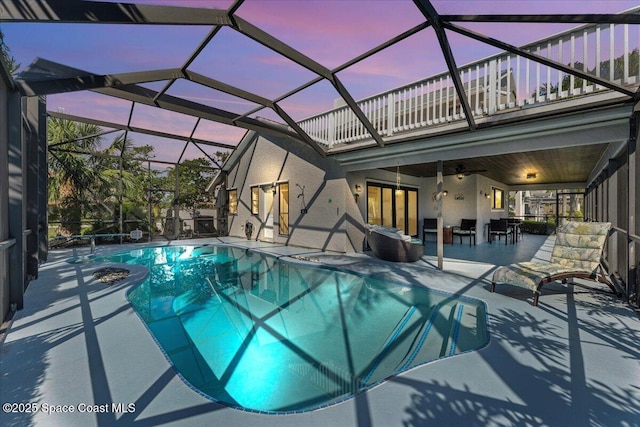 pool featuring ceiling fan, a patio, and glass enclosure