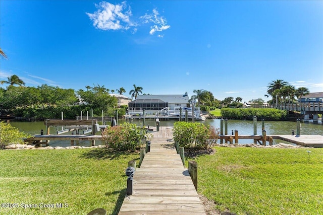 dock area featuring a water view, boat lift, and a lawn