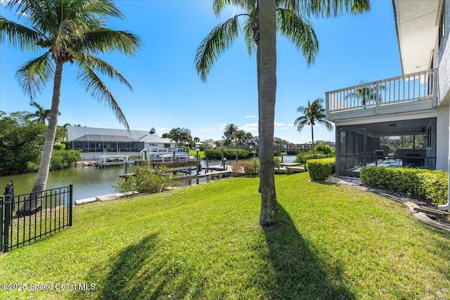 view of yard featuring a boat dock, a water view, and a balcony