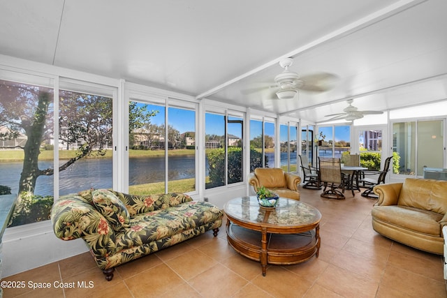 sunroom / solarium featuring a water view and a ceiling fan