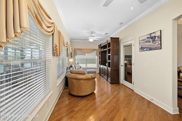 interior space featuring light wood-style flooring, visible vents, baseboards, and crown molding