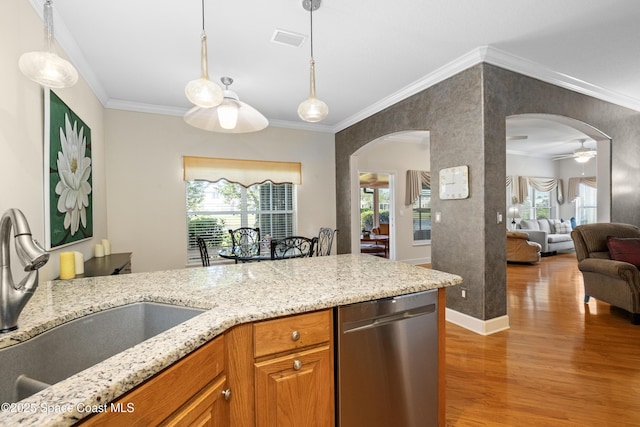 kitchen with arched walkways, crown molding, light wood-style flooring, a sink, and dishwasher