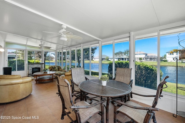 sunroom featuring a water view and ceiling fan