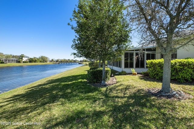 view of yard featuring a water view and a sunroom