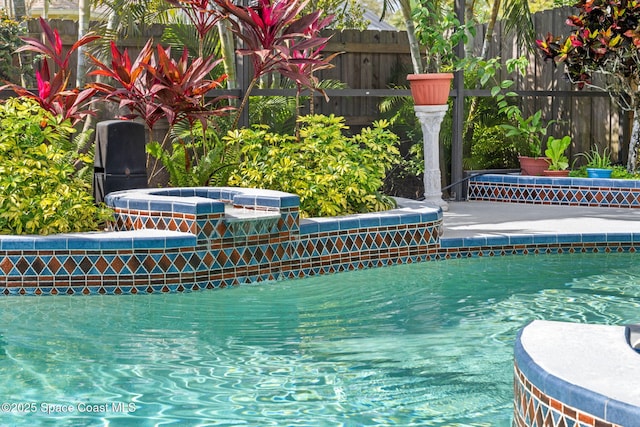 view of pool featuring an in ground hot tub, fence, and a fenced in pool