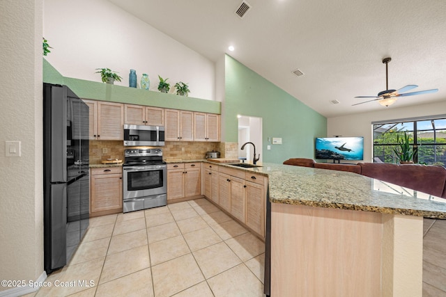 kitchen with visible vents, appliances with stainless steel finishes, a peninsula, light brown cabinets, and a sink