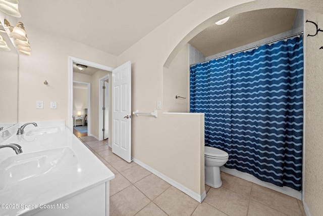 full bath featuring double vanity, a sink, and tile patterned floors