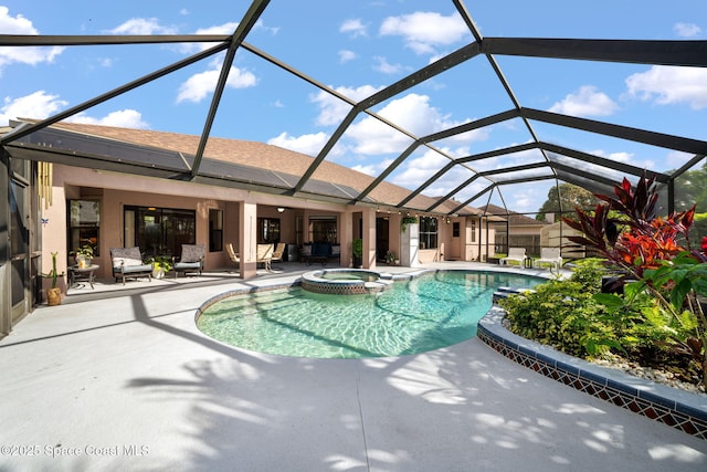 view of swimming pool featuring a pool with connected hot tub, a patio area, and a lanai