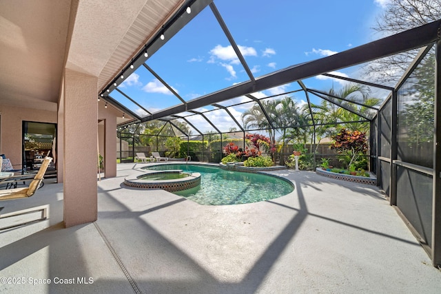 view of swimming pool featuring a pool with connected hot tub, glass enclosure, and a patio