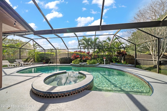 view of swimming pool featuring a patio area, a fenced backyard, a pool with connected hot tub, and a lanai