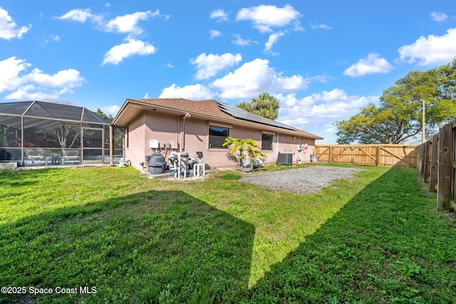 rear view of property with a lawn, a patio, a fenced backyard, central AC, and stucco siding