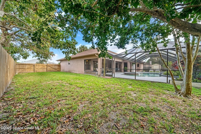 view of yard featuring a fenced backyard, a fenced in pool, and a lanai