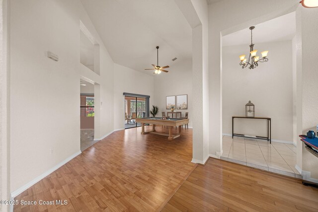 268 Lake Shore Dr, Merritt Island, FL 32953 - interior space featuring high vaulted ceiling, ceiling fan with notable chandelier, pool table, wood finished floors, and baseboards