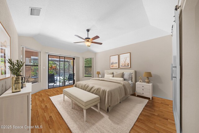 268 Lake Shore Dr, Merritt Island, FL 32953 - bedroom featuring a textured ceiling, visible vents, light wood-style floors, vaulted ceiling, and access to exterior