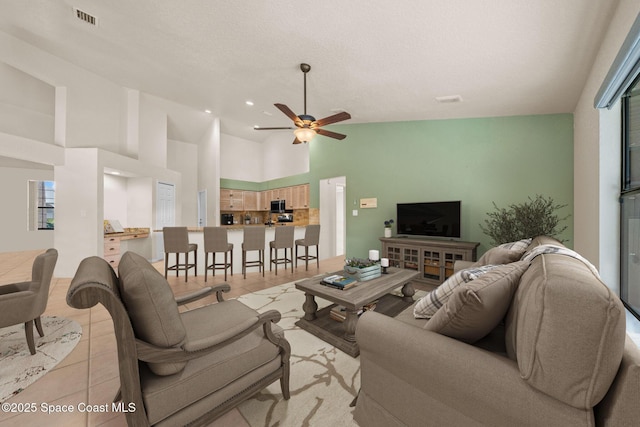 268 Lake Shore Dr, Merritt Island, FL 32953 - living room featuring light tile patterned floors, high vaulted ceiling, visible vents, and a ceiling fan