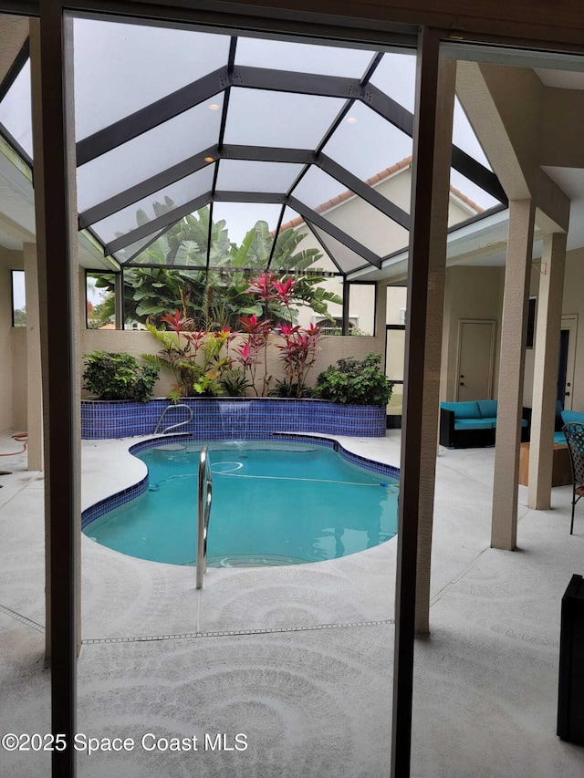 outdoor pool with a lanai and a patio area