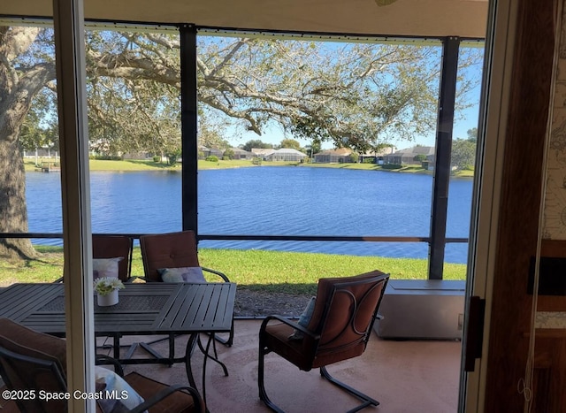 sunroom / solarium featuring a water view and a healthy amount of sunlight