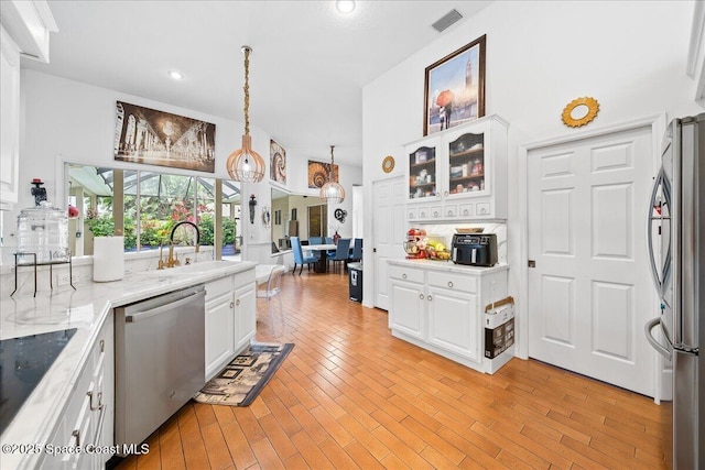 530 Carmel Dr, Melbourne, FL 32940 - kitchen with visible vents, stainless steel appliances, white cabinets, and a sink