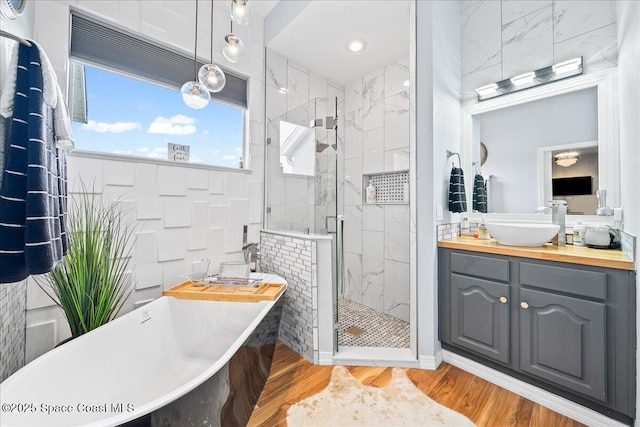 530 Carmel Dr, Melbourne, FL 32940 - full bath with wood finished floors, vanity, a freestanding bath, and a stall shower