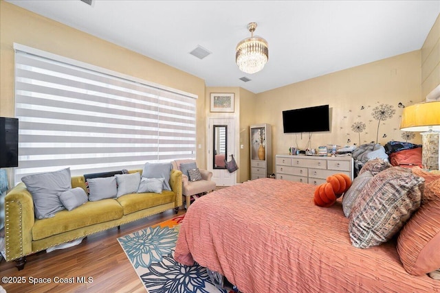 530 Carmel Dr, Melbourne, FL 32940 - bedroom with a notable chandelier, visible vents, and wood finished floors