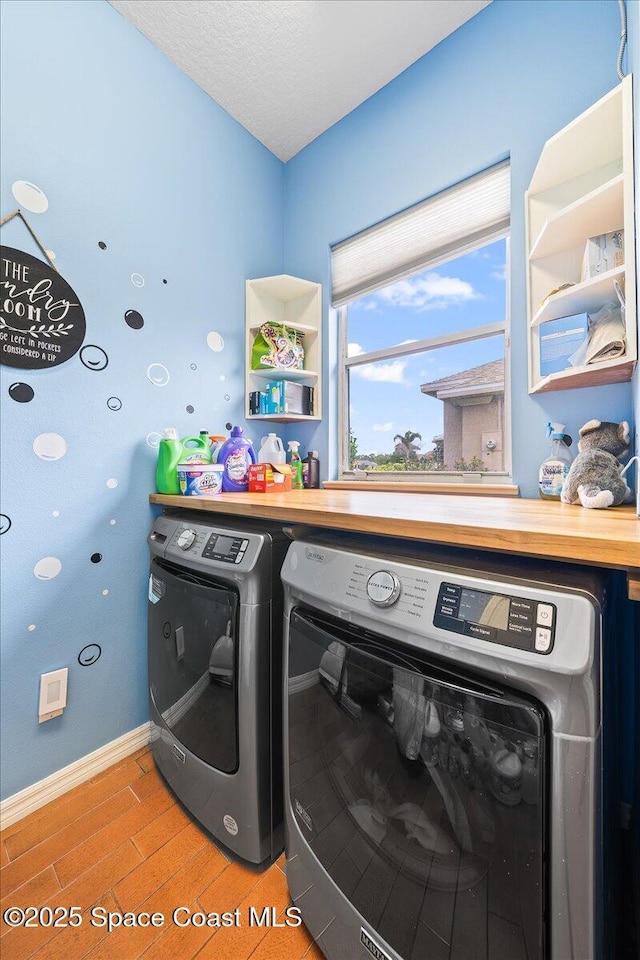 530 Carmel Dr, Melbourne, FL 32940 - laundry area with baseboards, washing machine and clothes dryer, laundry area, and light wood-style floors