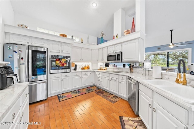 530 Carmel Dr, Melbourne, FL 32940 - kitchen with appliances with stainless steel finishes, white cabinetry, and high vaulted ceiling