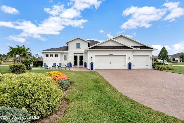 view of front of house featuring a front lawn, decorative driveway, and an attached garage