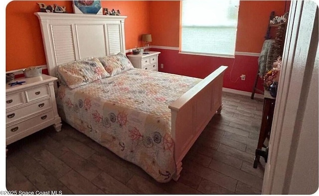 bedroom featuring baseboards and dark wood-style flooring