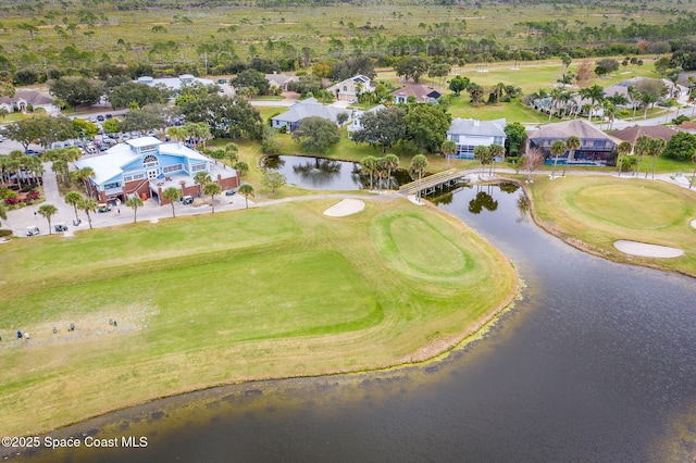 aerial view with golf course view and a water view