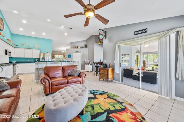 living area featuring light tile patterned floors, recessed lighting, ceiling fan with notable chandelier, and lofted ceiling