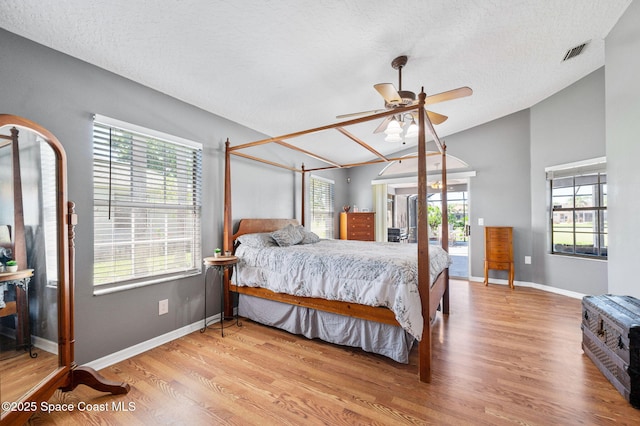 bedroom with wood finished floors, visible vents, lofted ceiling, and access to exterior