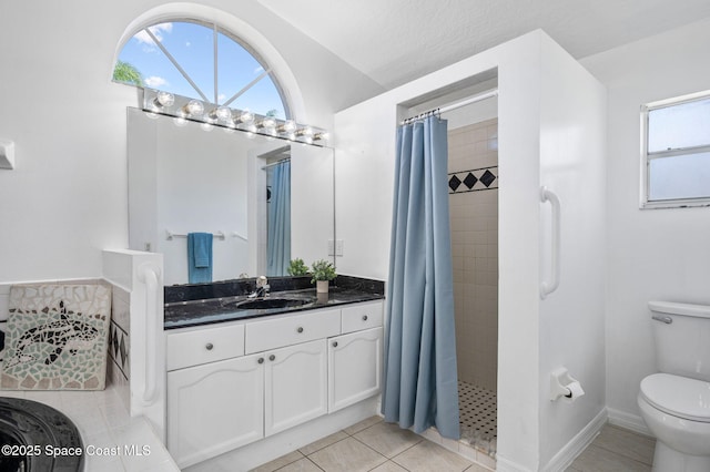 bathroom featuring vanity, tile patterned floors, toilet, and tiled shower