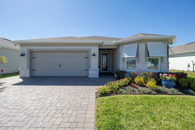 view of front of house with a garage, decorative driveway, stone siding, and stucco siding