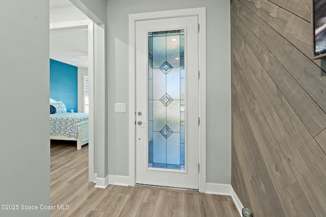 doorway featuring plenty of natural light, baseboards, and wood finished floors