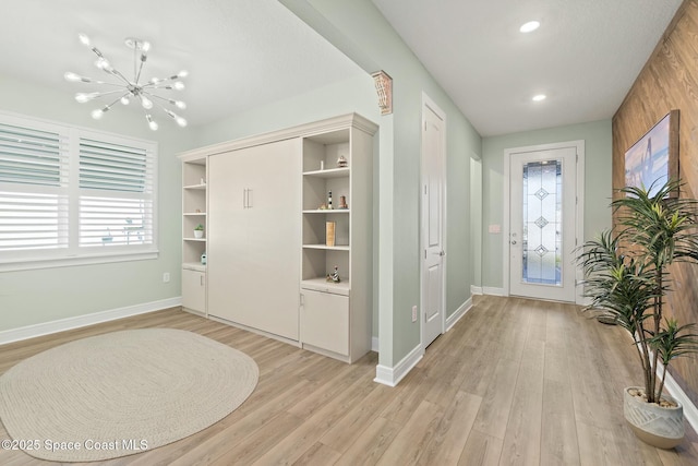 interior space with light wood-style floors, recessed lighting, a notable chandelier, and baseboards