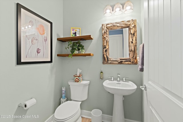 half bathroom with toilet and baseboards