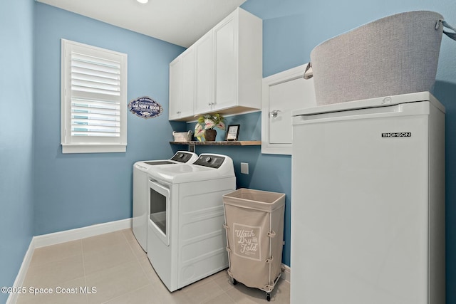 laundry room with light tile patterned floors, cabinet space, baseboards, and separate washer and dryer