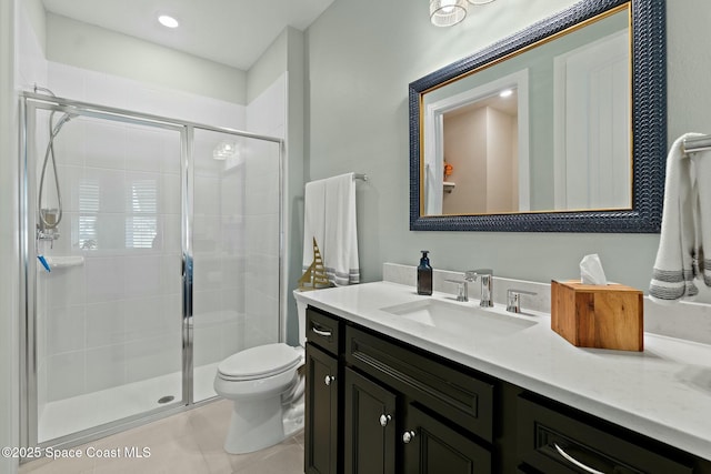 bathroom with toilet, a shower stall, vanity, and tile patterned floors