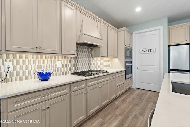 kitchen featuring custom exhaust hood, stainless steel appliances, and light countertops