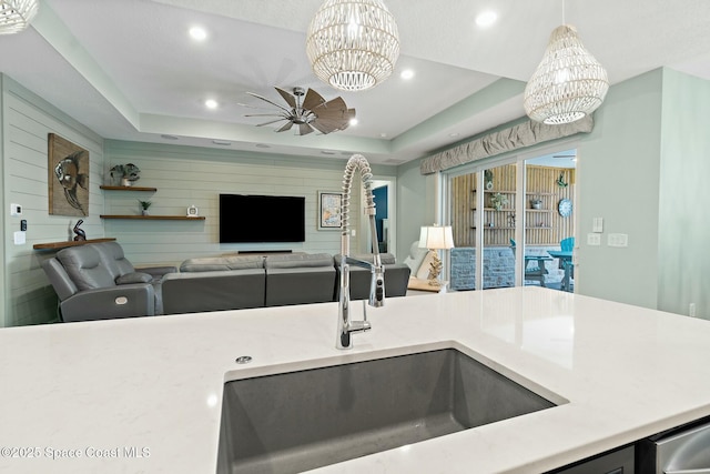 kitchen with a tray ceiling, a sink, and recessed lighting