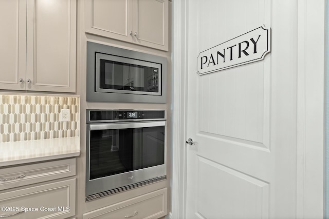 kitchen featuring stainless steel appliances, tasteful backsplash, and light countertops