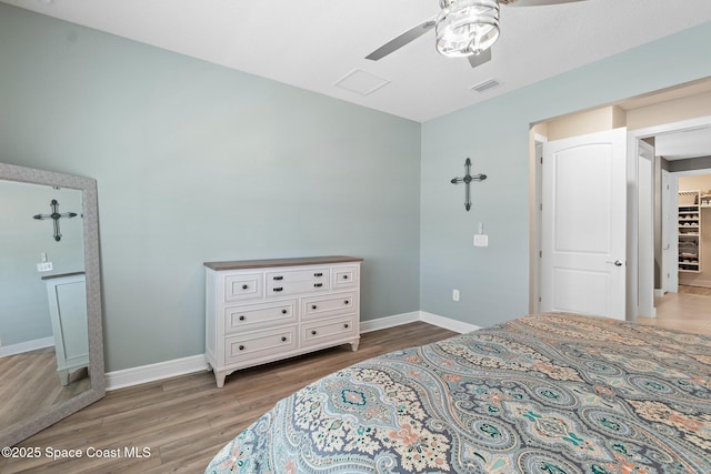 bedroom featuring ceiling fan, light wood finished floors, visible vents, and baseboards