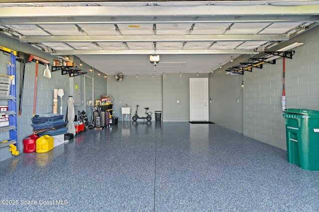 garage featuring concrete block wall and a garage door opener