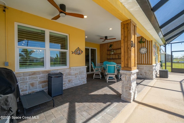 view of patio / terrace with a lanai, grilling area, and a ceiling fan