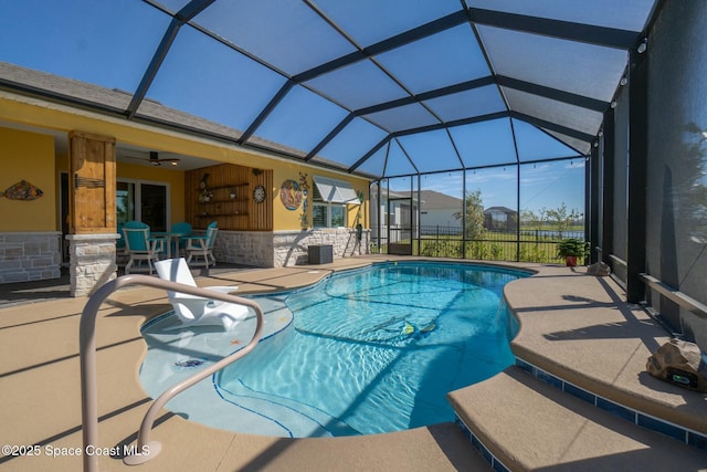 outdoor pool with a lanai, a patio area, and a ceiling fan