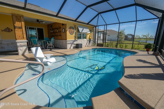 pool featuring a patio, glass enclosure, and a ceiling fan