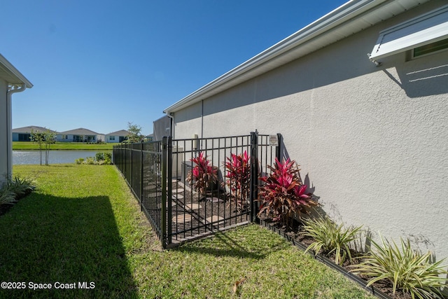 view of yard with a water view and fence